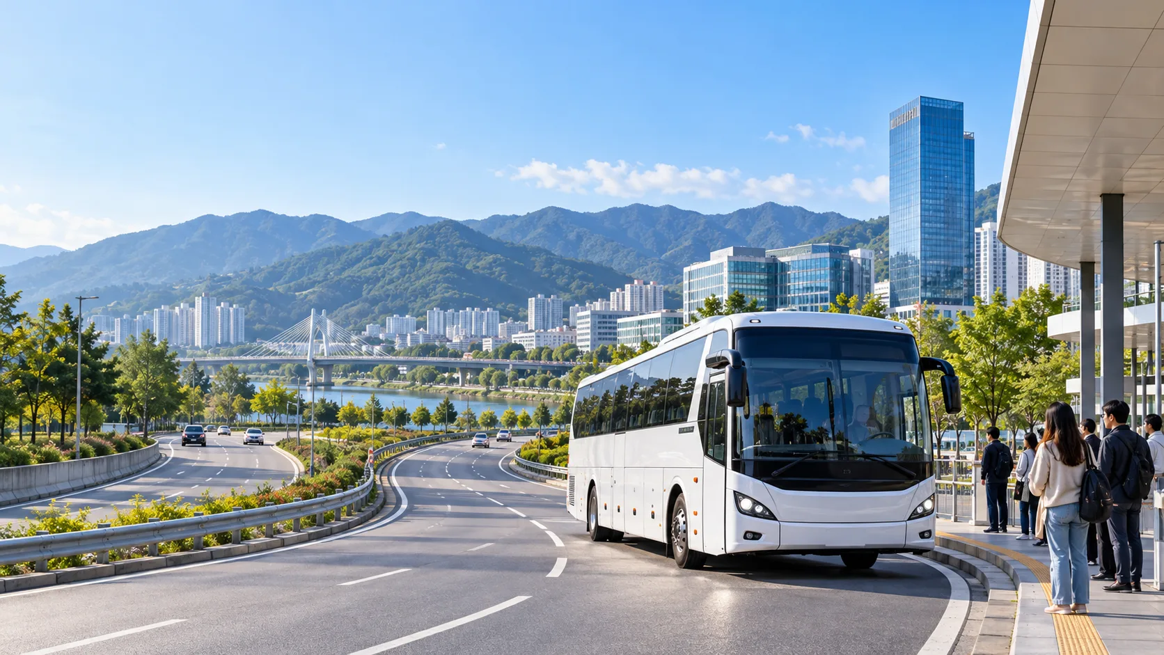 산과 현대적인 도심을 배경으로 원주의 도로변 승차장에 정차한 흰색 고속버스